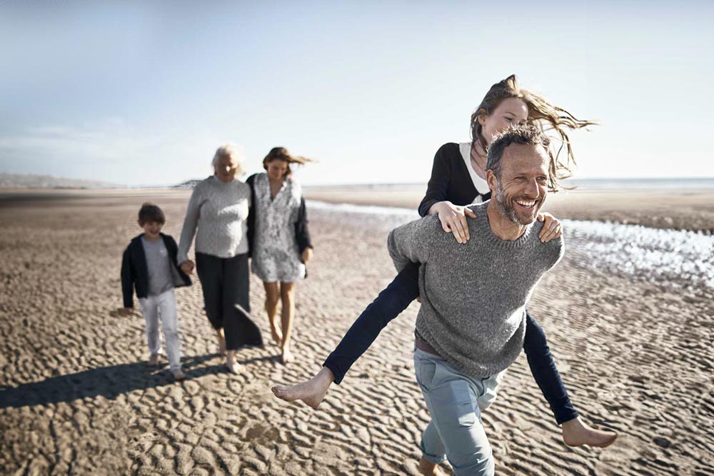 Familj som promenerar på en strand
